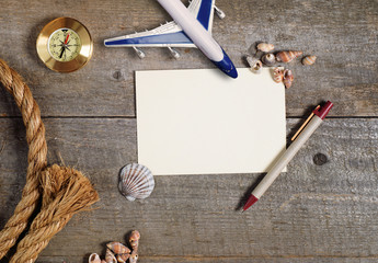 Travel items on wooden table. Notebook blank page mock-up with Travel and vacation items. Top view with copy space