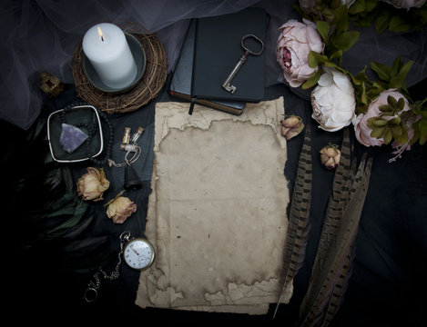 Vintage table with paper, flowers, old watch and candle