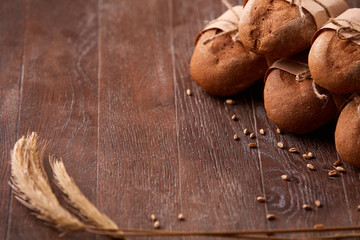 different bread on the wooden table, wheat, paper bags, rope, ears of wheat