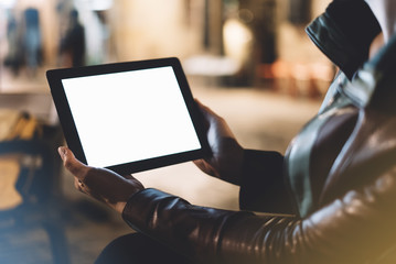 Girl holding in hands on blank screen tablet on background illumination glow bokeh light in night atmospheric city, hands using template mobile computer on lights glitter street; mock up gadget