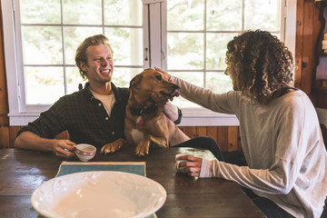 Couple playing with a dog in a cabin