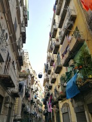 Fototapeta na wymiar NAPLES, ITALY - JANUARY 28, 2017 : street view of old city center of Naples with clothes hanging in the street.
