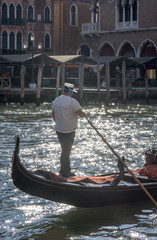 Fototapeta na wymiar Detail of a gondolier on his gondola while sailing on the Grand Canal near the Rialto market, Venice, Italy