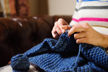 Close-up of woman hands knitting colorful wool yarn.