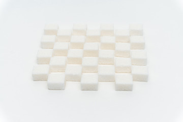 Sugar cubes are staggered on a light background