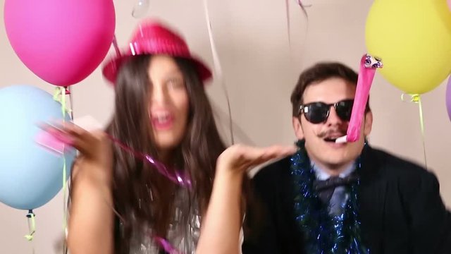 Cool young couple dancing and sending kisses in photo booth
