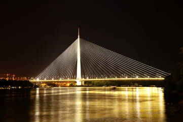 Fototapeta premium Abstrakcyjny obraz - lampki nocne Bridge wiszący. Zmierzch Skyline