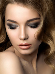 Beauty portrait of young woman with golden makeup