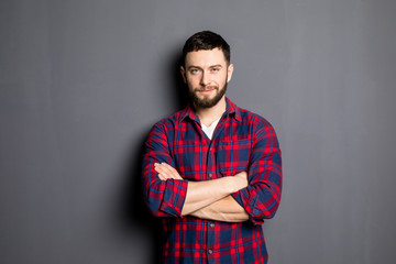 Happy young man. Portrait of handsome young man in casual shirt keeping arms crossed and smiling