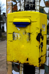 Old yellow mailbox hanging on the brick wall of a house in the village