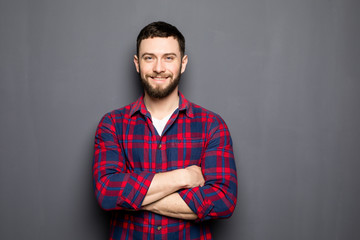 Portrait of handsome young man in casual shirt keeping arms crossed and smiling