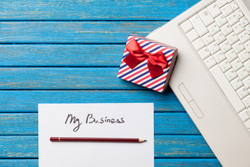 photo of paper My business, laptop and cute gift on the wonderful blue wooden background