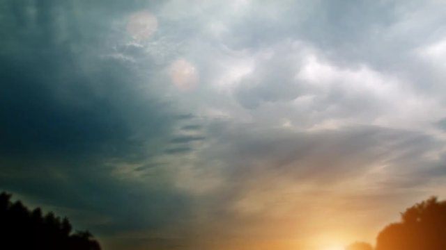 extreme thunderstorm with massive clouds in cloudscape and backlight sun