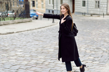 Fototapeta premium Outdoor portrait of young beautiful lady in spring, she is calling taxi