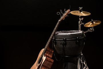 percussion instruments with an acoustic guitar on wooden boards with a black background