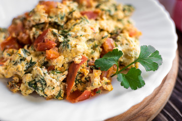 Fried eggs with tomato on dark wooden table