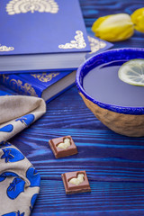 Lemon tea, books and yellow tulips on a wooden background