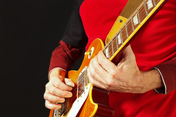 Musician playing the electric guitar on a dark background