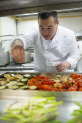 chinese cook adding salt to vegetables