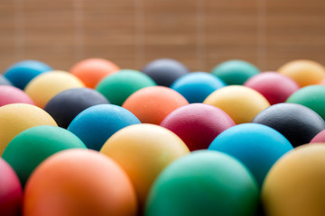 Multicolored easter eggs, on a textured wooden background. The concept of a holiday and a happy Easter. with space for text