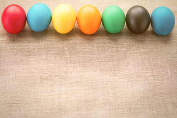 Multicolored easter eggs in a row on a cloth background. The concept of a holiday and a happy Easter. With space for text