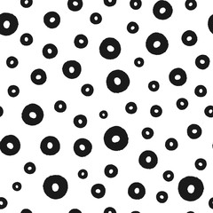 Background with scattered round elements painted with a rough brush. Seamless pattern. Grunge.