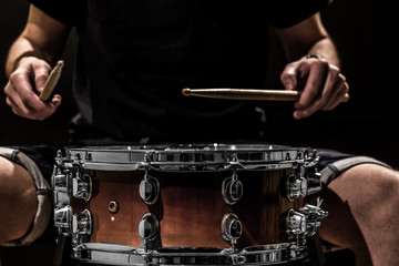 man plays musical percussion instrument with sticks a musical concept with the working drum