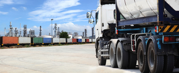 Freight Train Backdrop oil refinery and silver tanker lorry or truck in parking