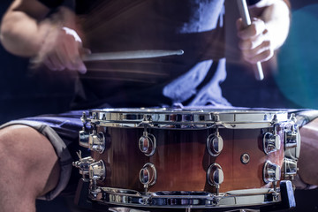 man plays musical percussion instrument with sticks, a musical concept, beautiful lighting on the stage
