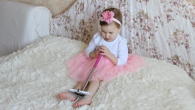 A little beautiful funny girl takes pictures of Selfie on the phone