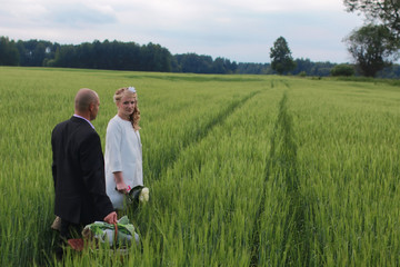 Couple lovers walking in field in summer day