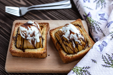Baked apples with toast and ice cream on a rustic background