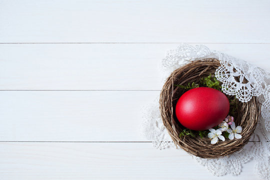 Easter background with a nest, red egg and with flowers