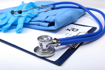 Medical stethoscope, Gloves, RX prescription on blue doctor uniform closeup. Medical tools and instruments shop, blood pressure measurement concept. you can place your text.