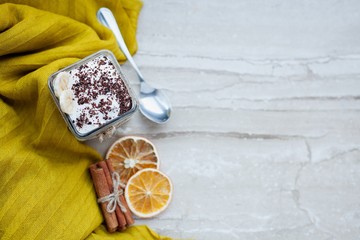 Creamy pudding with a banana, chocolate and cinnamon on a marble background.