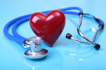 Medical stethoscope and red heart isolated on blue mirror background. you can place your text.