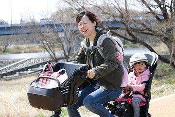 Naklejka premium 電動自転車に子供を乗せるお母さん