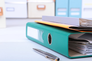 Folder file, pen, pencil and note on the desk. blurred background.