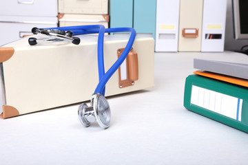 Folder file, stethoscope and note on the desk. blurred background.