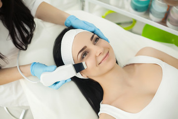 Woman receiving electric facial peeling at european beauty salon.
