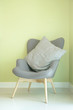 Gray armchair with green wall in background