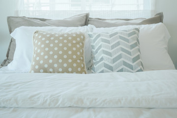 Yellow and green pillow on bed in pastel interior bedroom