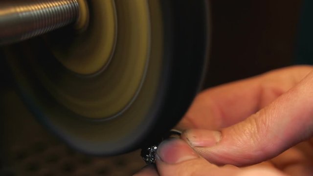 Process of polishing a silver ring on a polishing equipment close-up is the final stage of making a ring