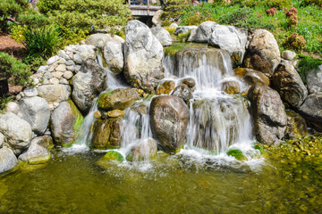 Fototapeta na wymiar Man made waterfall in a garden