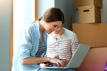 Happy young couple unpacking or packing boxes and moving into a new home