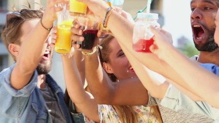 Close up of group of beautiful young people hanging out and toasting at rooftop party on sunny day - Powered by Adobe
