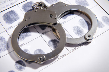 Handcuffs laying on top of fingerprint chart