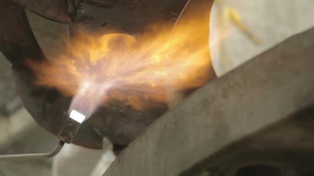 Dilating with fire huge piece of iron for proper assembly, in the maintenance of mining equipment (Crusher)