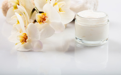 Fototapeta na wymiar Moisturizing cream and orchid on white background