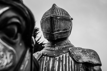 black and white picture of a knight in armor who rides on the horse